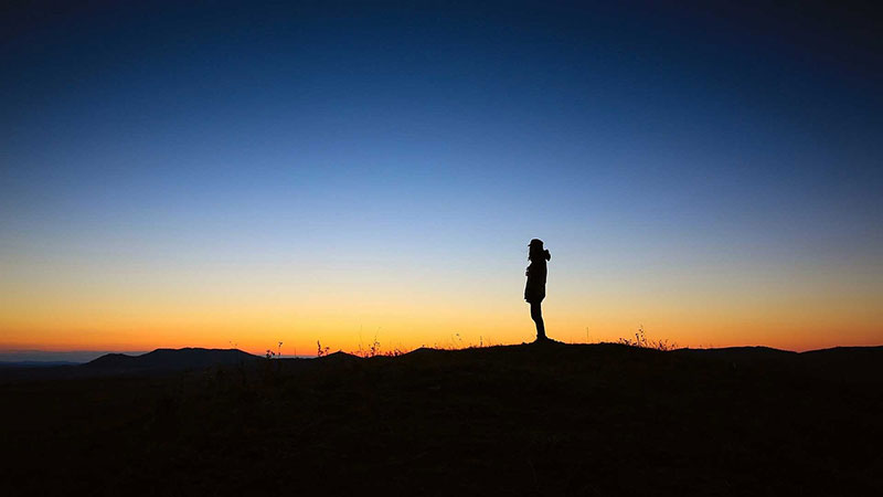 Silhouette of a lone hiker at sunset