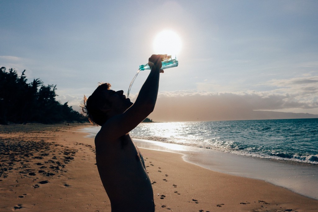 Man Drinking Water on a Beach