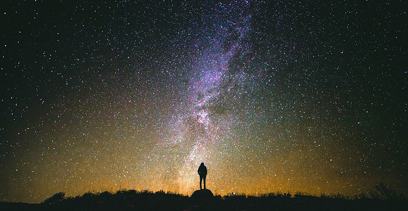 Silhouette of hiker against night sky